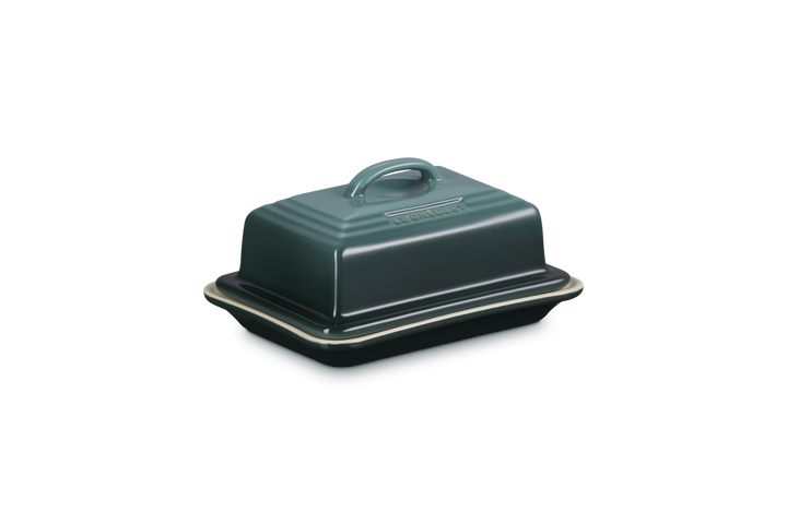 Green ceramic butter dish with lid on a white background