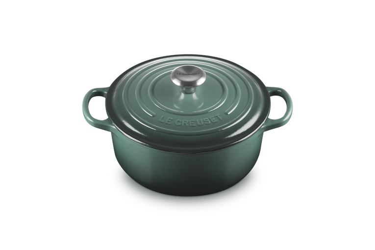 Green cast iron cookware pot with lid on a white background