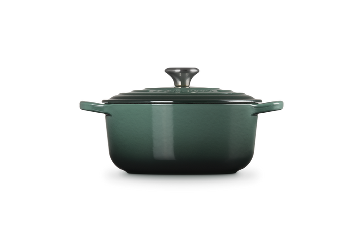 Green enameled cast iron Dutch oven with lid on a white background