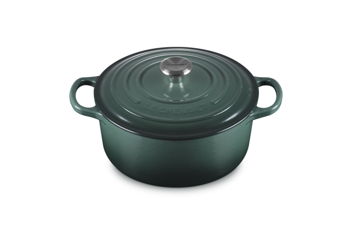 Green cast iron cookware pot with lid on a white background