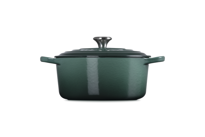 Green enameled cast iron Dutch oven on a white background