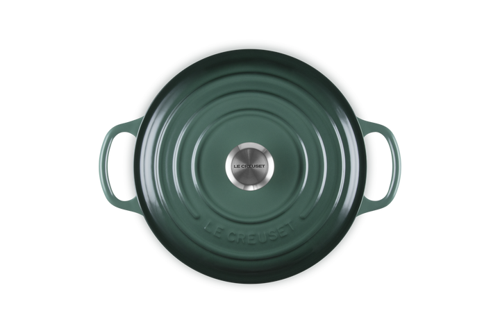 Green cast iron cookware with 'Le Creuset' branding on a white background