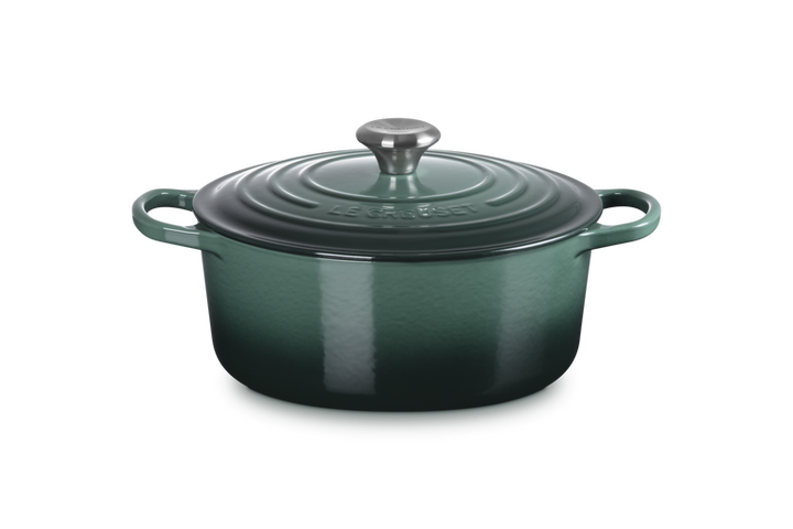 Green enameled cast iron Dutch oven with lid on a white background