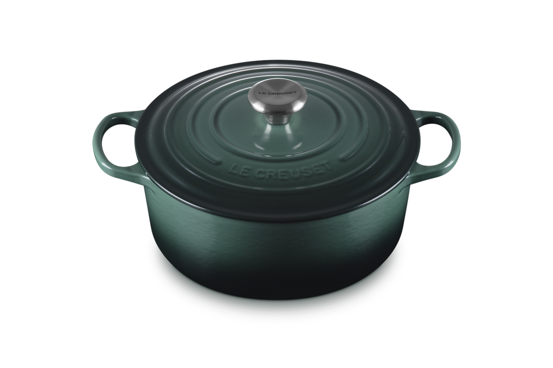 Green cast iron cookware pot with lid on a white background
