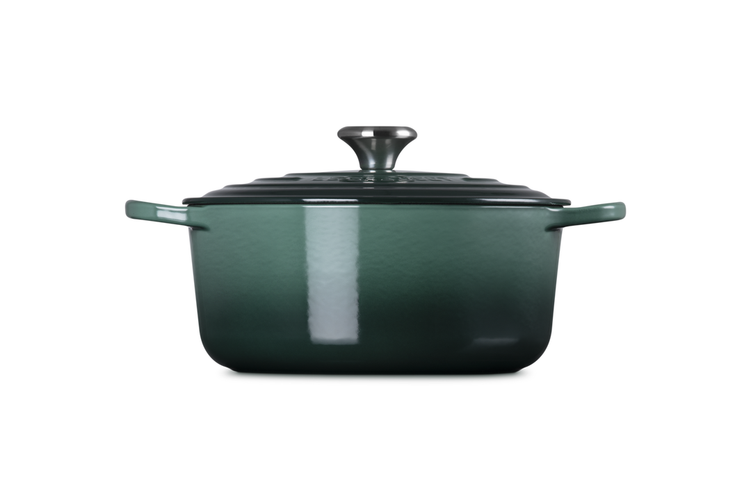 Green enameled cast iron Dutch oven on a white background