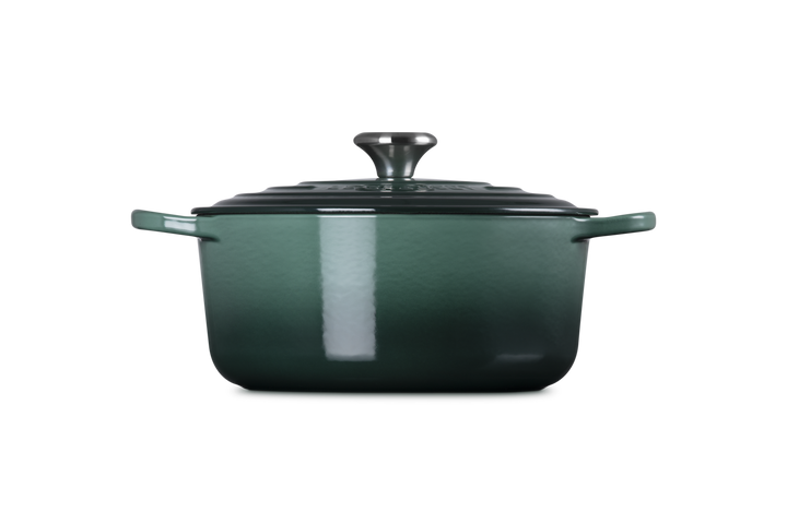 Green enameled cast iron Dutch oven on a white background