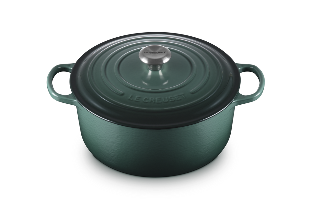 Green cast iron cookware pot with lid on a white background