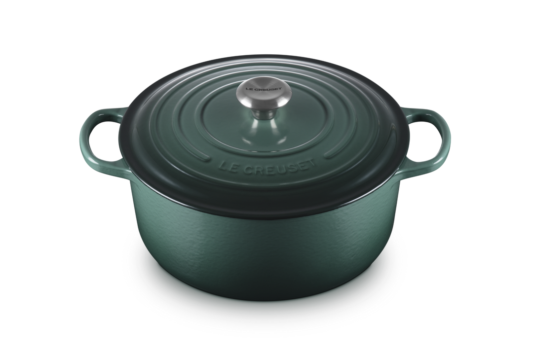 Green cast iron cookware pot with lid on a white background