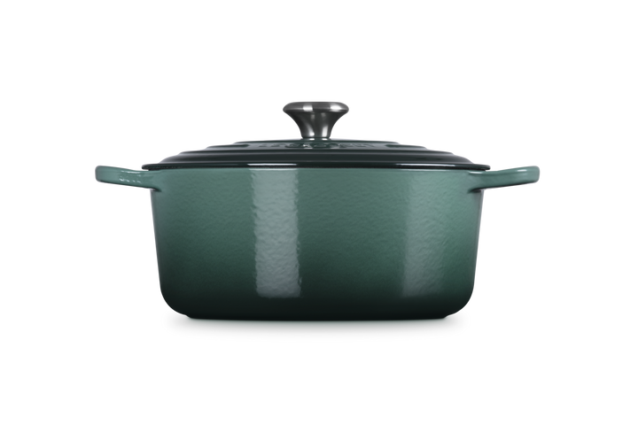 Green enameled cast iron Dutch oven with lid on a white background