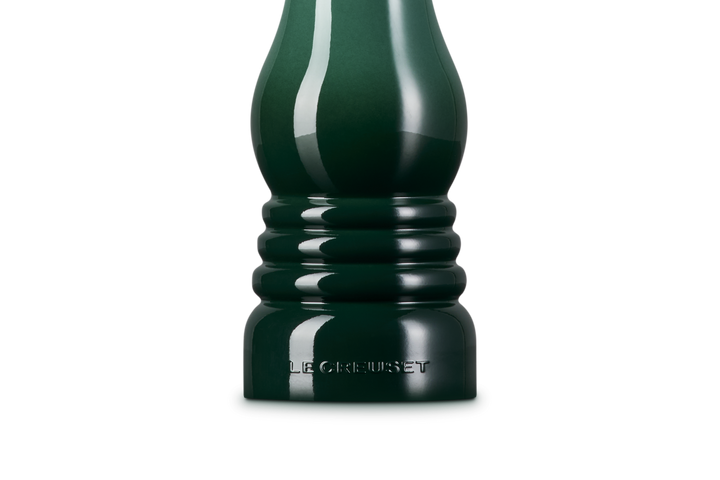 Dark green pepper grinder on a white background