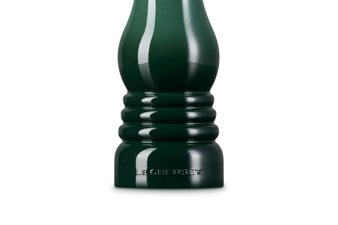 Dark green pepper grinder on a white background