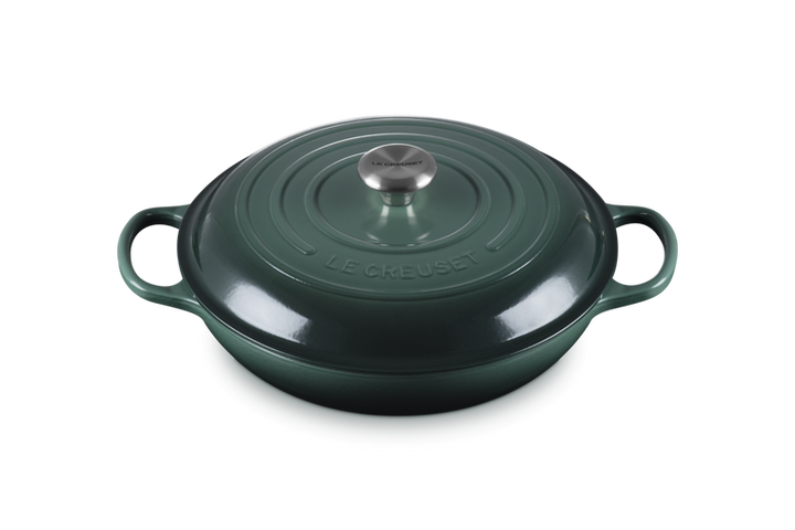 Green cast iron cookware with handles on a white background