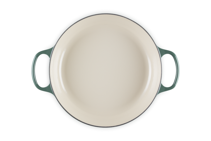 Round ceramic dish with handles on a white background