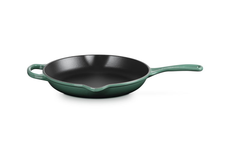 Green frying pan with black interior on a white background