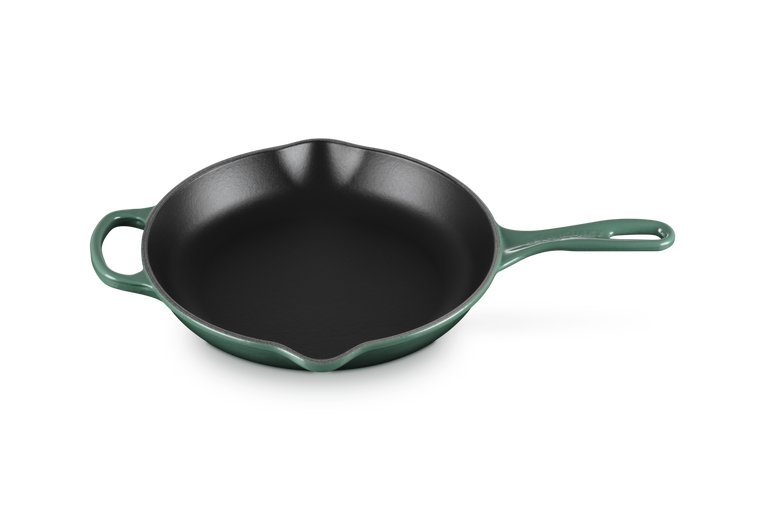 Green cast iron skillet on a white background