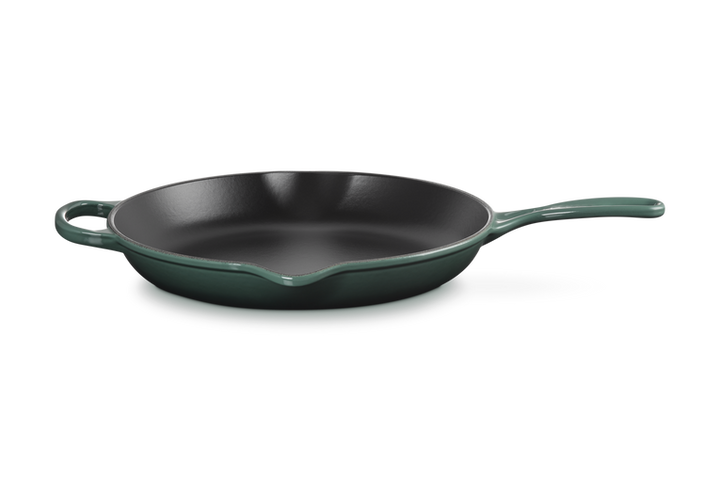 Green cast iron frying pan on a white background