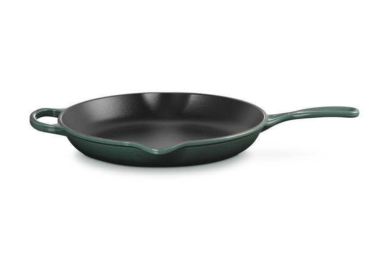 Green cast iron frying pan on a white background