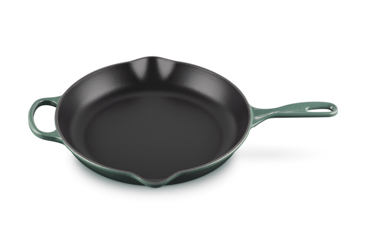 Green cast iron skillet on a white background