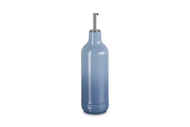 Light blue ceramic oil bottle with a metallic cap on a white background