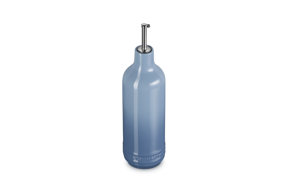 Light blue ceramic oil bottle with a metallic cap on a white background