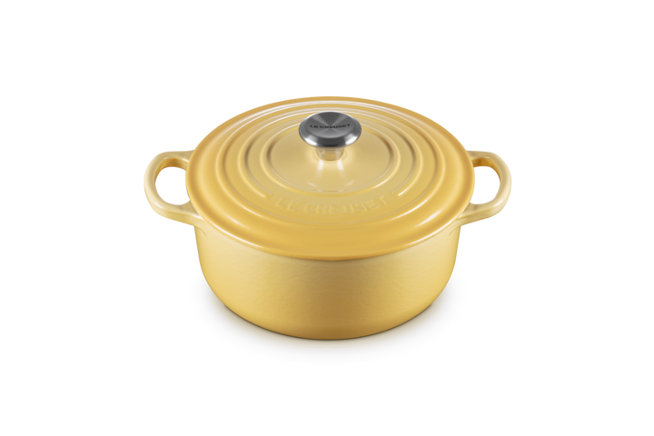 Yellow round cast iron cookware with lid on a white background