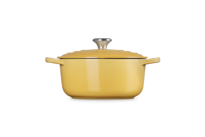 Yellow enameled cast iron Dutch oven with lid on a white background