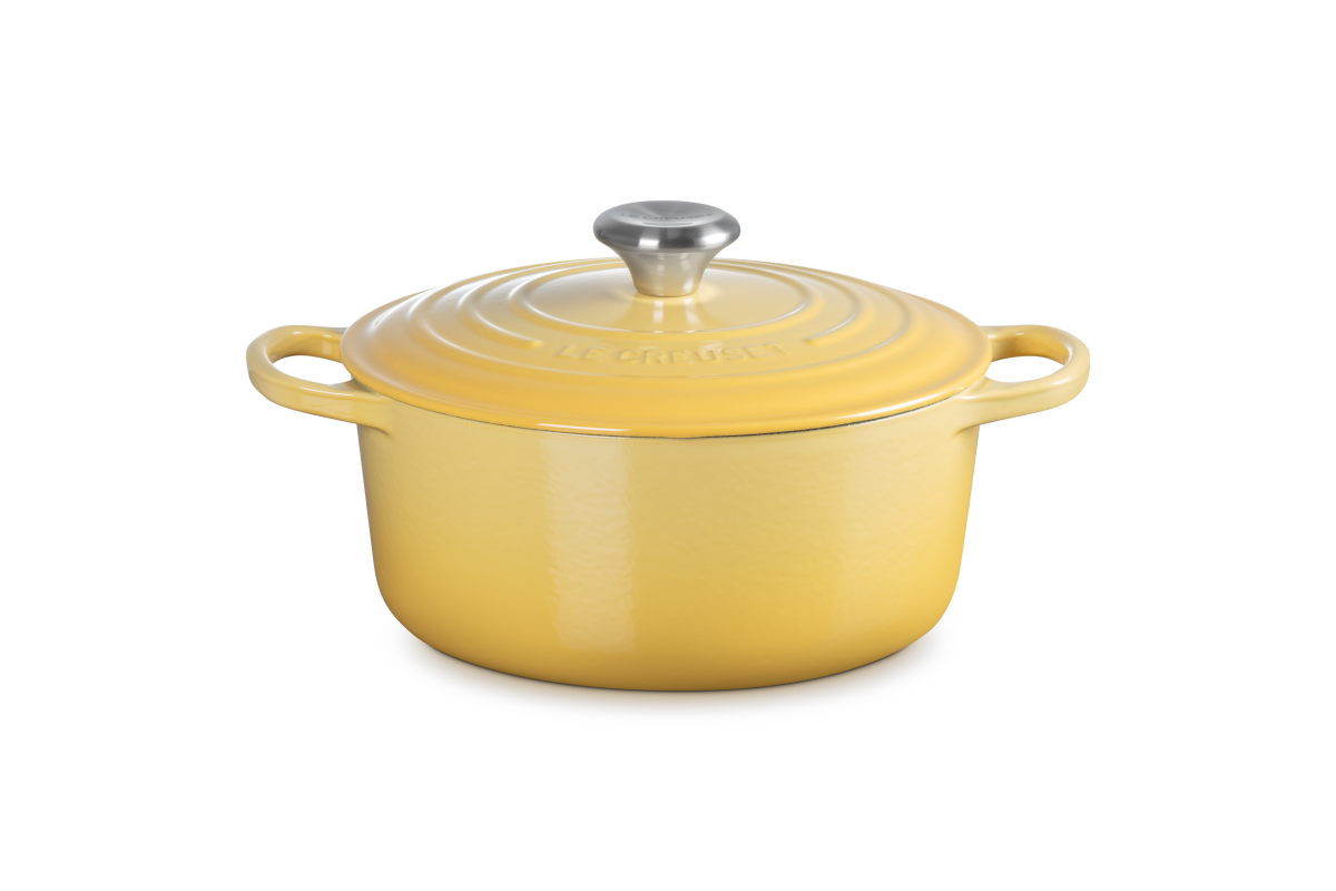 Yellow enameled cast iron cookware pot with lid on a white background