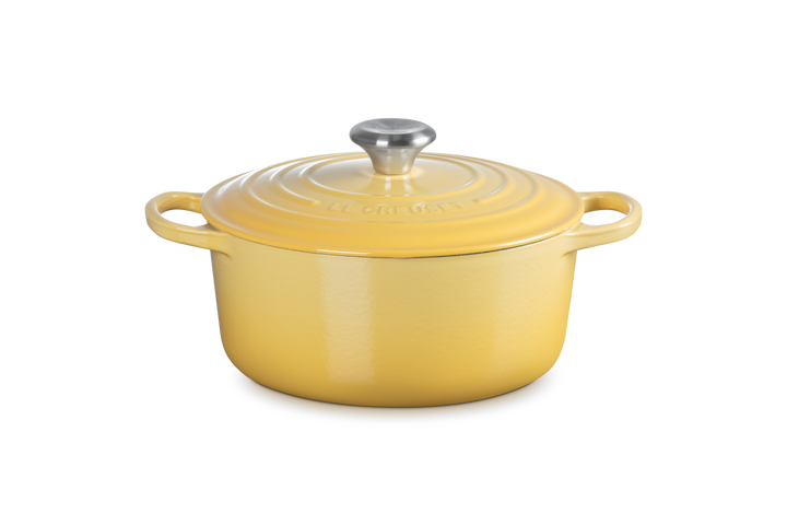 Yellow enameled cast iron cookware pot with lid on a white background