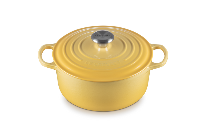 Yellow enameled cast iron Dutch oven with lid on a white background