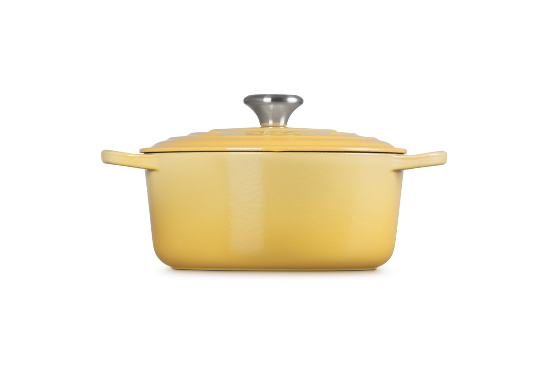 Yellow enameled cast iron Dutch oven on a white background