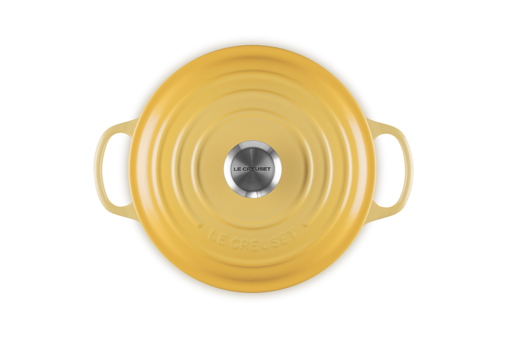 Yellow ceramic dish with handles on a white background