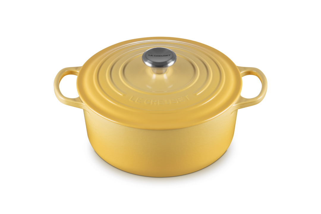 Yellow enameled cast iron Dutch oven with lid on a white background