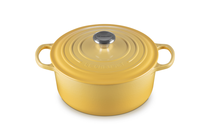 Yellow enameled cast iron Dutch oven with lid on a white background