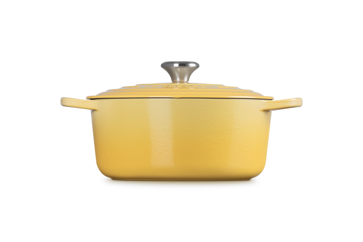 Yellow enameled cast iron Dutch oven with lid on a white background