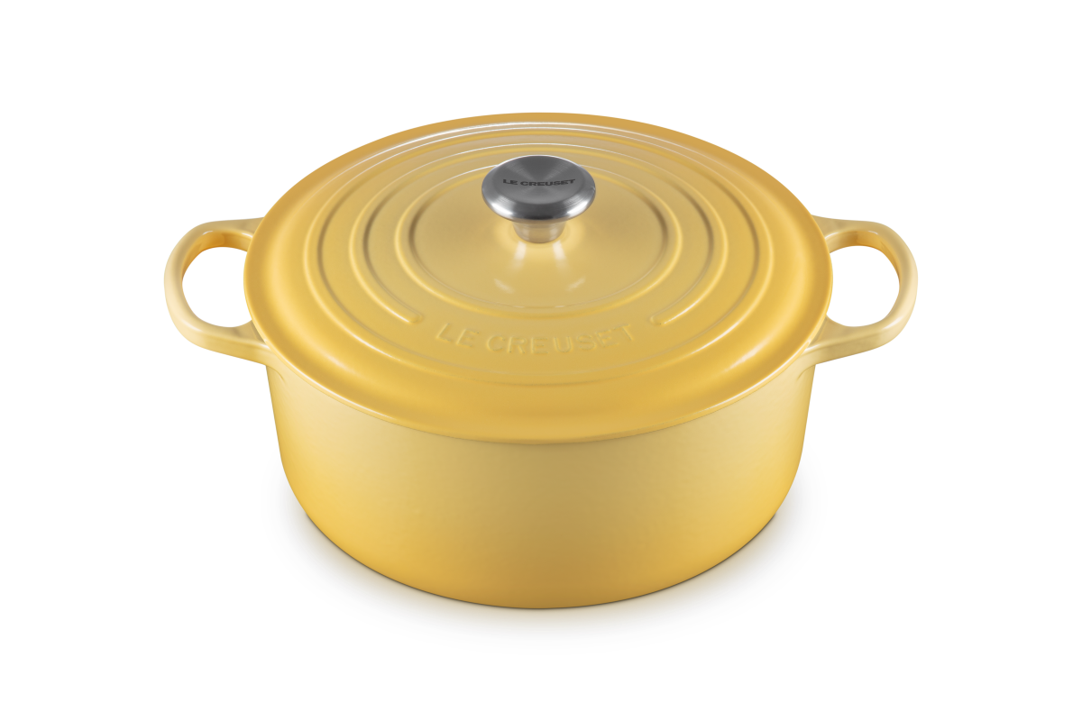 Yellow cast iron cookware pot with lid on a white background