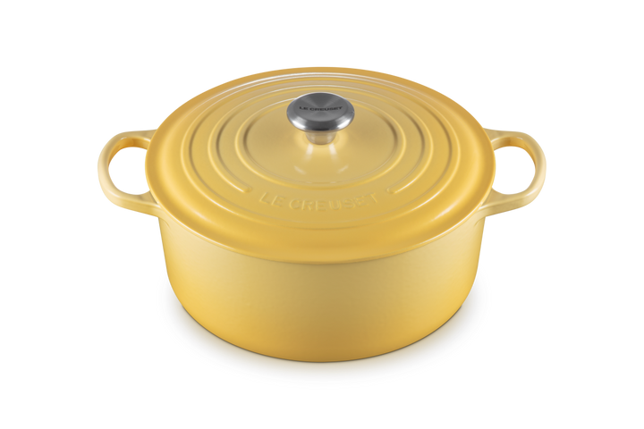 Yellow cast iron cookware pot with lid on a white background