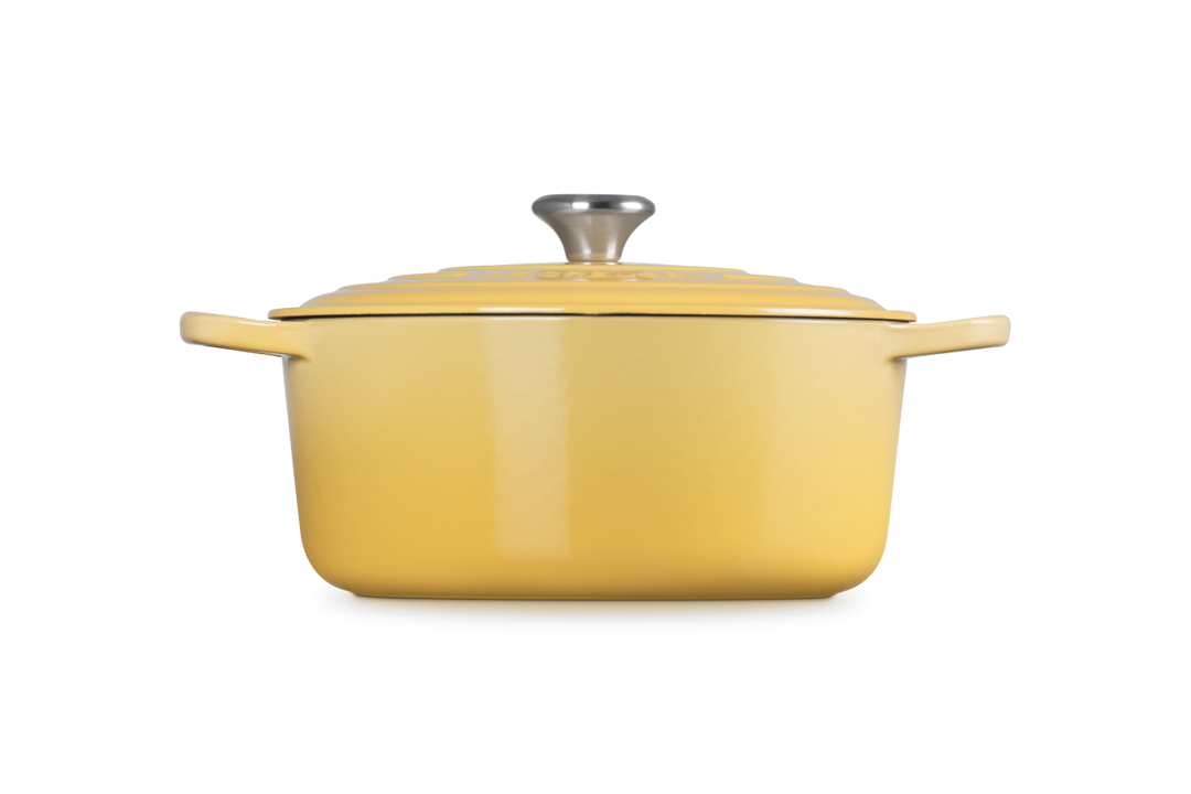 Yellow enameled cast iron Dutch oven with lid on a white background
