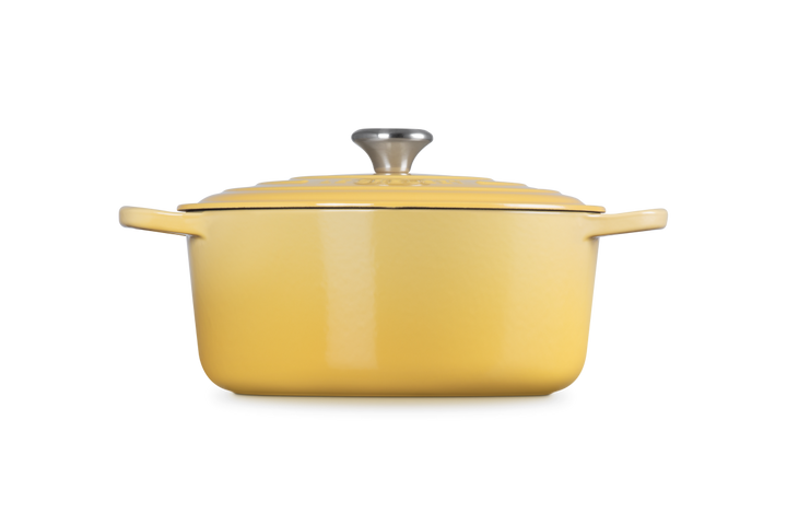 Yellow enameled cast iron Dutch oven with lid on a white background