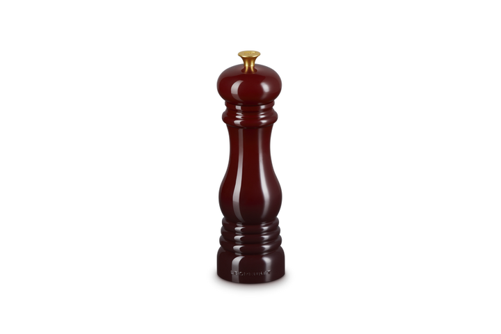Le Creuset Garnet pepper grinder on a white background