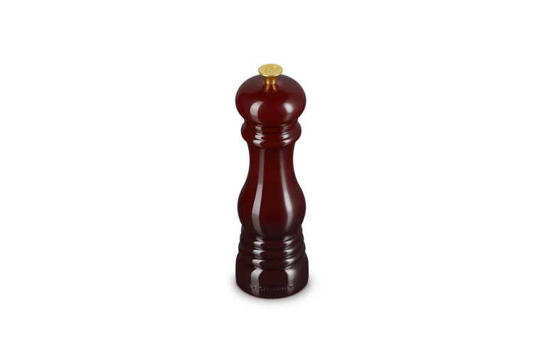 Le Creuset garnet pepper grinder on a white background