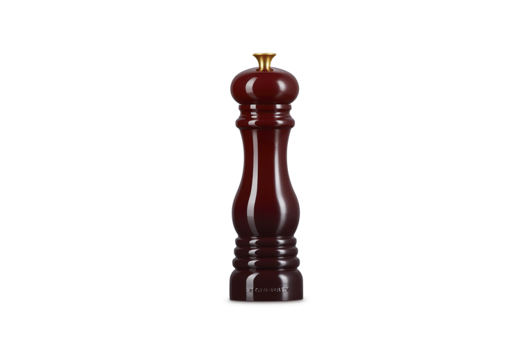 Le Creuset garnet pepper grinder on a white background