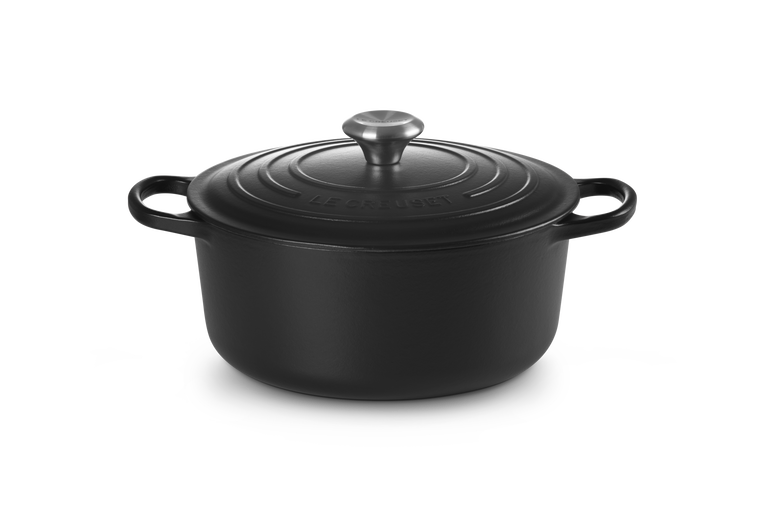 Black cast iron cookware pot with lid on a white background