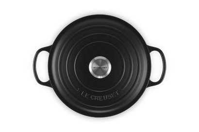 Black Le Creuset cast iron skillet on a white background