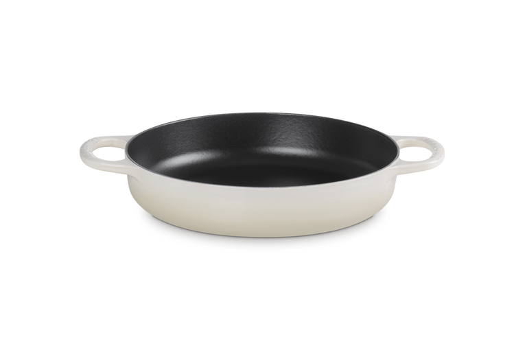 Le Creuset cast iron pan with handles on a white background