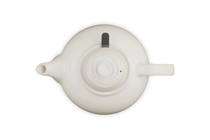Le Creuset cream ceramic teapot on a white background