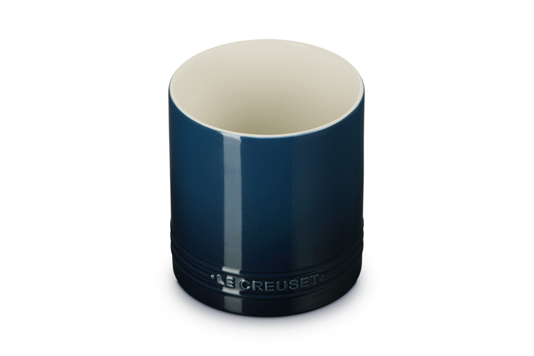 Blue utensil jar with beige interior on a white background