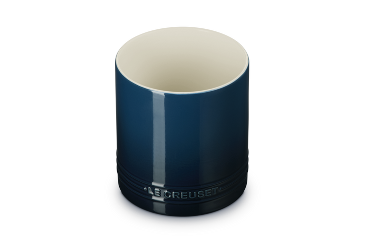 Blue utensil jar with beige interior on a white background