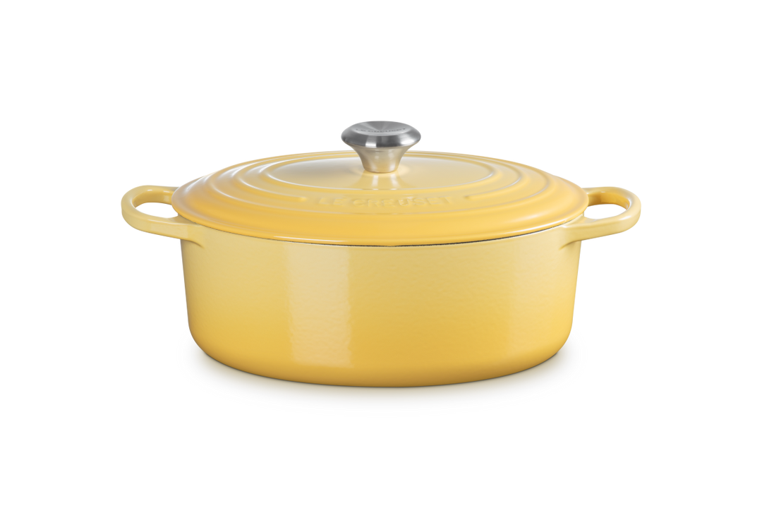 Yellow enameled cast iron Dutch oven with a lid on a white background