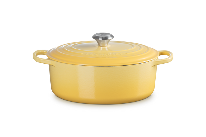 Yellow enameled cast iron Dutch oven with a lid on a white background