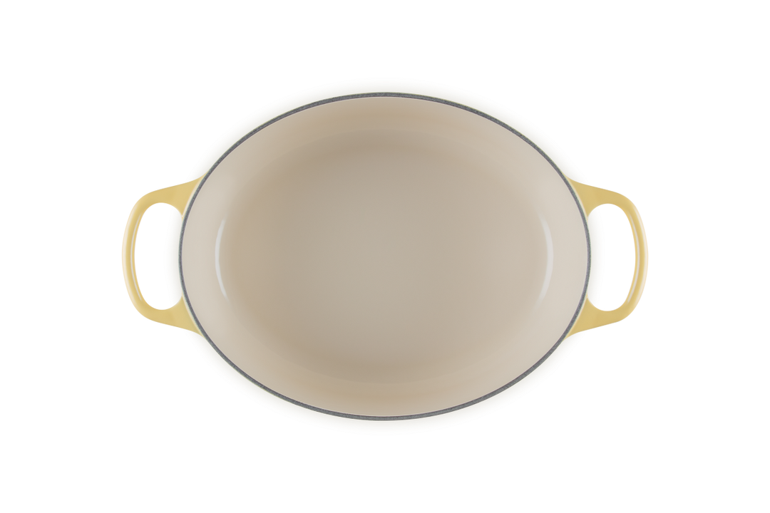 Beige enameled cast iron cookware with yellow handles on a white background